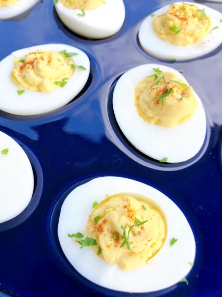 garnished deviled eggs in a blue serving dish