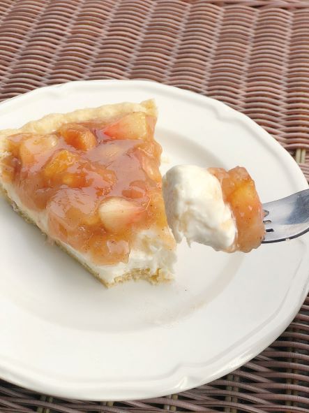 taking a bite of spiced peach pie on white plate