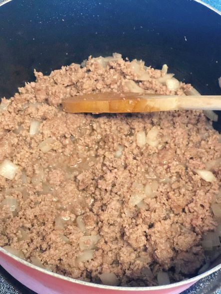 ground beef and onion cooking in pot on stove