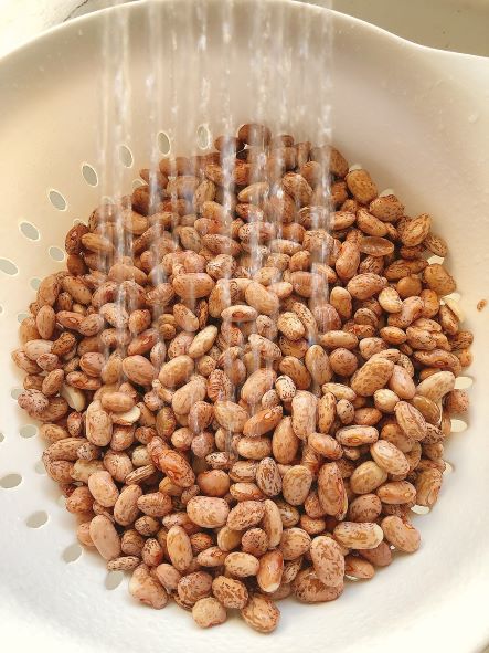 draining and rinsing pinto beans in colander