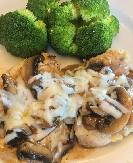 cheesy mushroom chicken plated with steamed broccoli