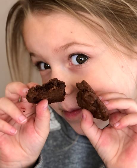kid holding up chocolate chocolate chip cookie