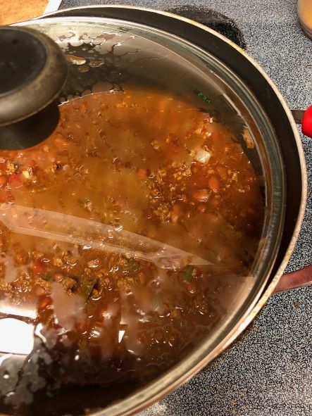 cooking curry chili on stove with lid cracked