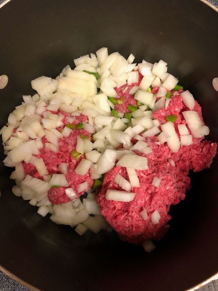 cooking ground beef, onion, garlic, and bell pepper in pot on stove