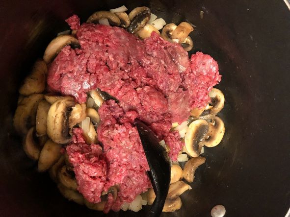 ground beef added to onion and mushrooms in pot