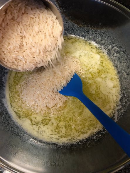 adding white rice to melted butter