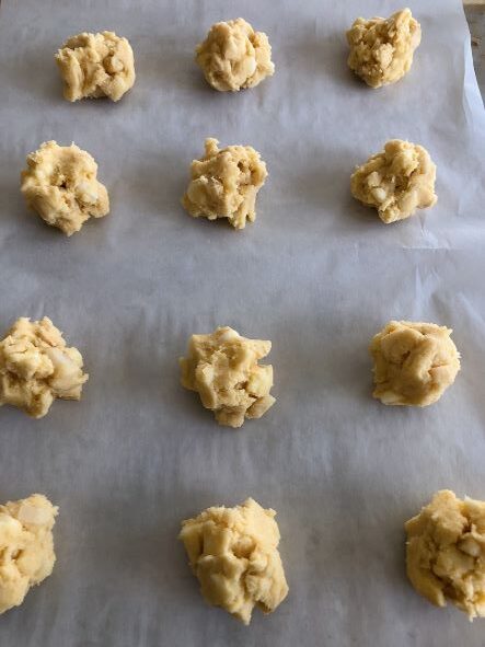 white chocolate macadamia cookie dough on parchment-lined baking sheet