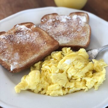 creamy scrambled eggs with toast and orange juice