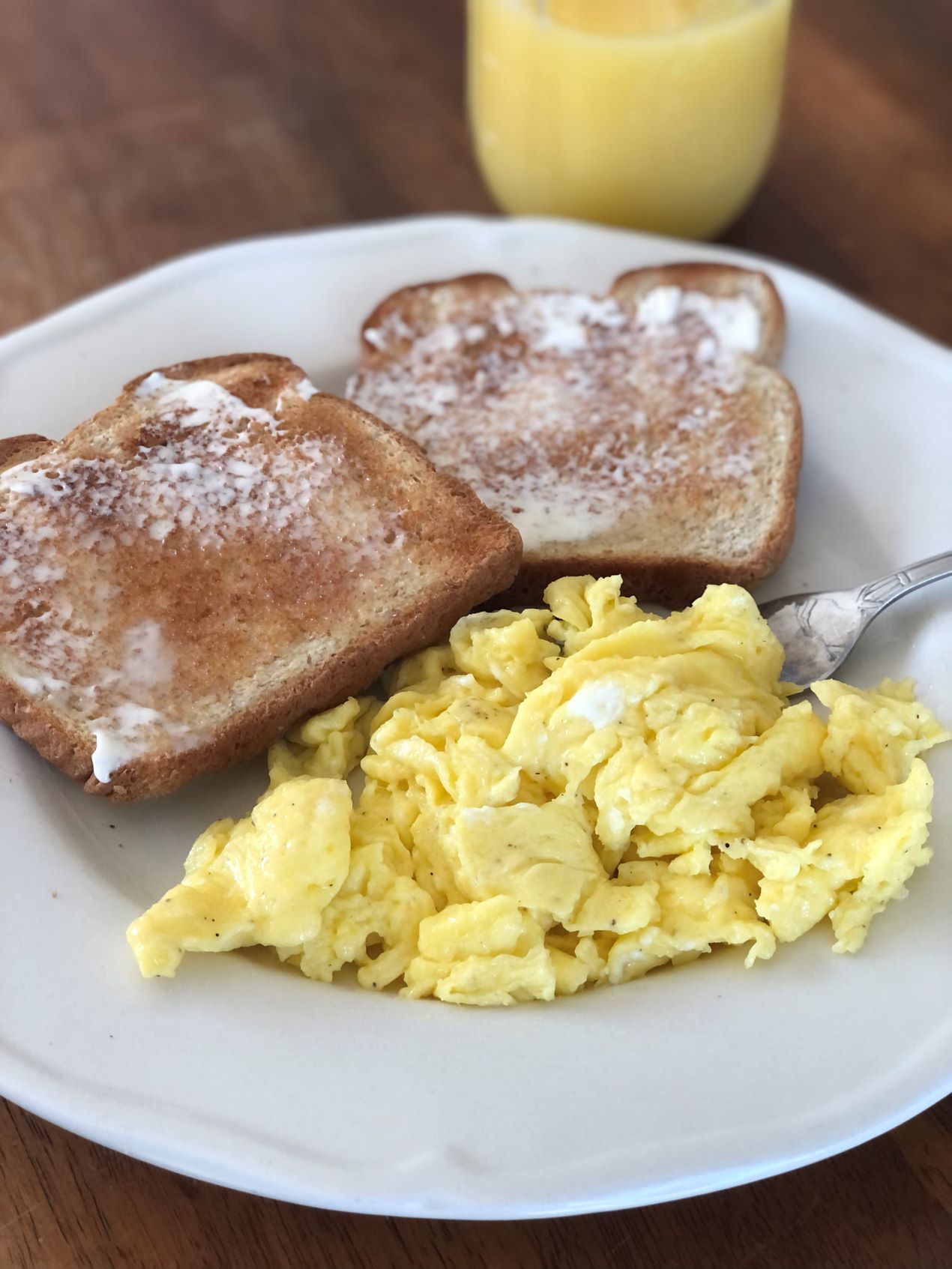 creamy scrambled eggs with toast and orange juice