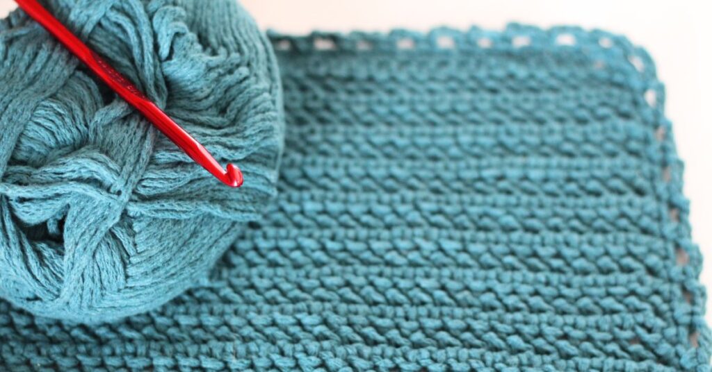 30-minute crochet washcloth with skein of yarn and crochet hook