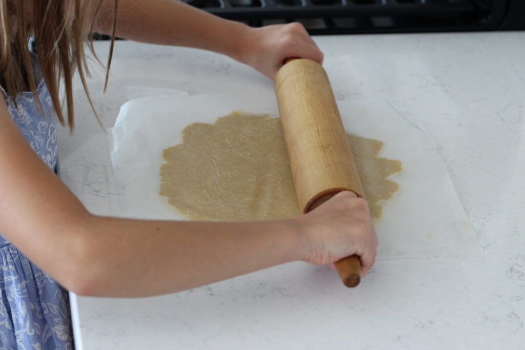 little girl rolling pie crust dough