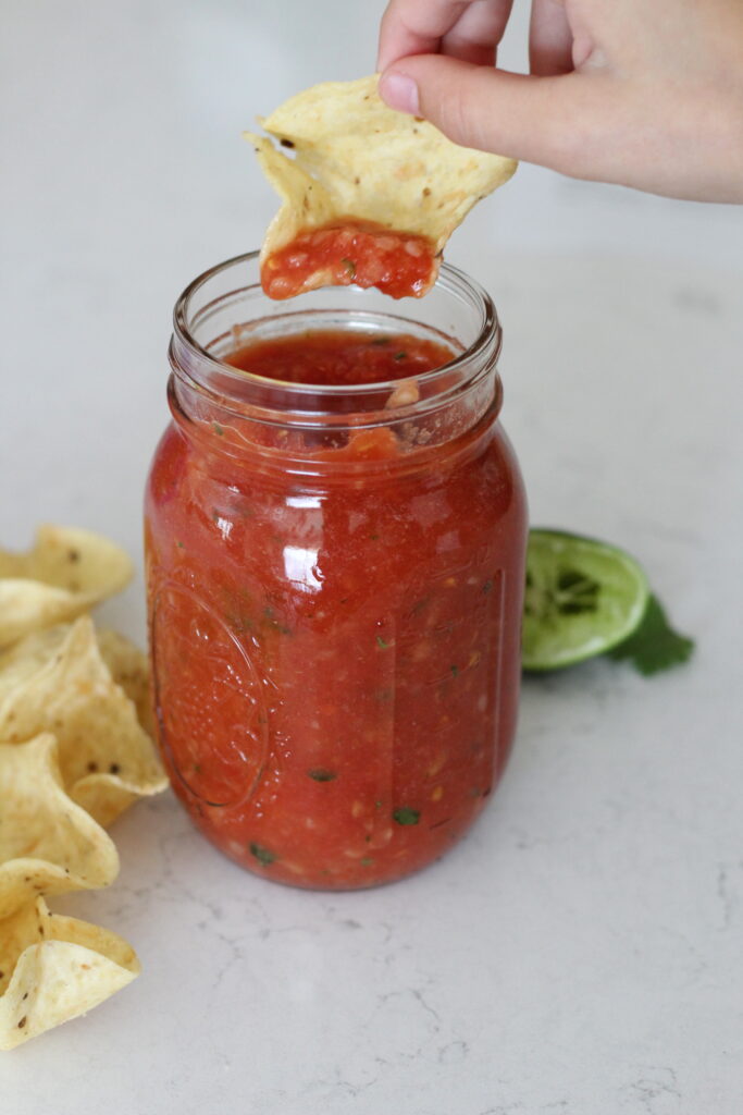 fresh salsa recipe in a mason jar with tortilla chips and lime